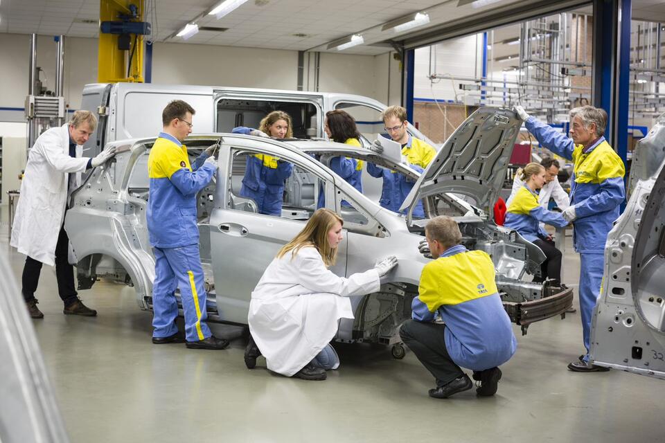 Several Tata Steel technicians working on a car frame