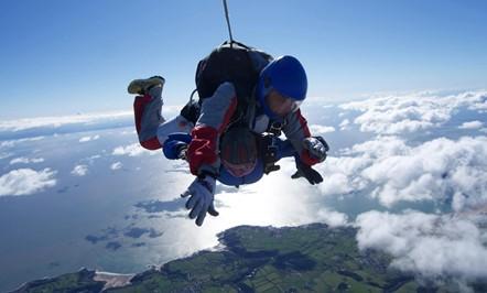 Woman jumping out of a plane with a parachute